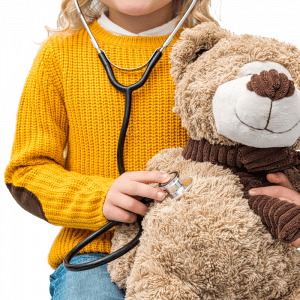 little girl with stethoscope and bear in hand